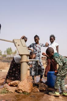 African school age children gathering around a sub saharian village faucet, Riccardo Mayer, Shutterstock